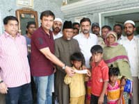 Mr Akberuddain Owaisi presenting 50, 000 to orphan children