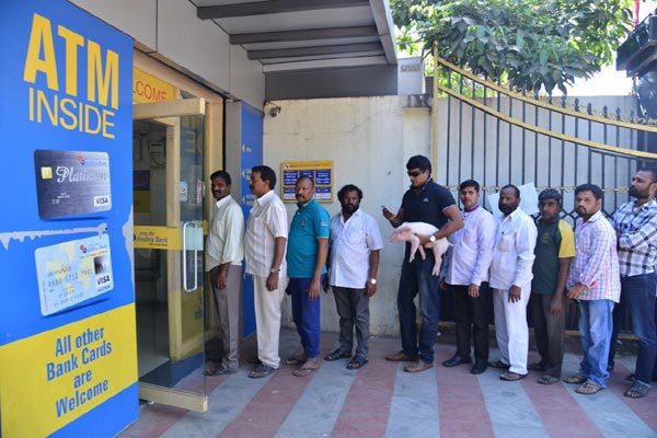 Ravi Babu with Adugo Piglet standing in ATM quque 